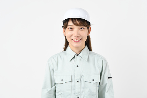 Young asian worker woman standing wearing construction helmet