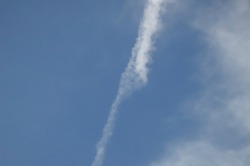 Blue sky and vapor trail on a slightly cloudy day