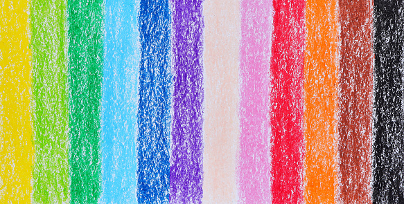 Multicolored crayon on paper drawing background. Colored crayon background rainbow. Wax crayon hand drawing on paper.Background