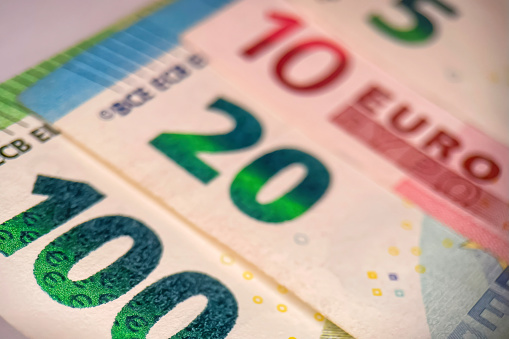 Close-up image of the Euro symbol at the centre of a collection of modern Euro notes.