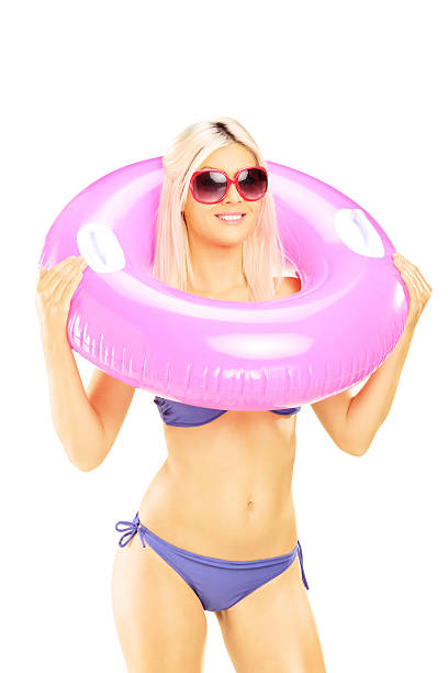 istock Blond female in bikini holding a swimming ring 180328901