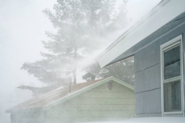 istock strong wind blowing snow off the roof in blizzard 1803290888
