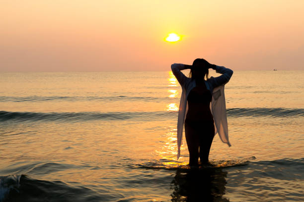 istock Woman pretty with bikini and silhouette on beach 1803358826
