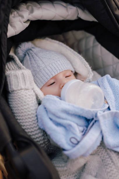 istock A little boy drinks milk from a bottle in a stroller 1803365952