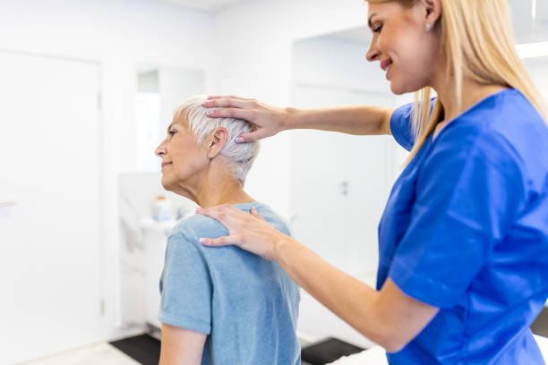 Licensed chiropractor or manual therapist doing neck stretch massage to relaxed female patient in clinic office. Young woman with whiplash or rheumatological problem getting professional doctor's help quiropráctico con licencia o terapeuta manual que realiza masajes de estiramiento del cuello a pacientes femeninas relajadas en el consultorio de la clínica. mujer joven con latigazo cervical o problema reumatológico que recibe ayuda de un médico profe