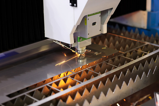 Sheet metal cutting by CNC laser cutting machine. Selective focus.