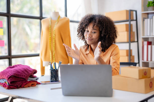 istock Young African American business owner is video calling with a customer about a product using a laptop computer. 1803474433