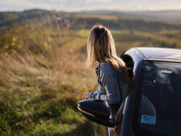 istock Carefree woman looking at view through a car window. 1803500763
