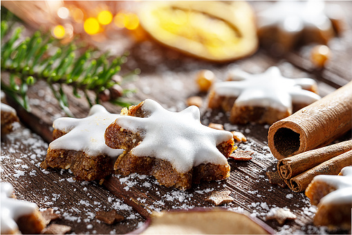 Cinnamon stars with fir branch on wooden table
