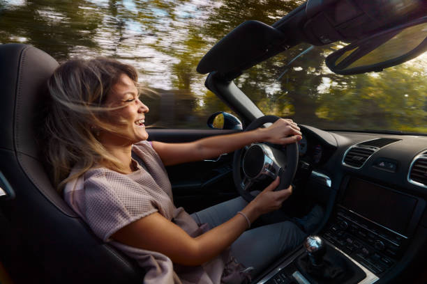 istock Cheerful woman going on a trip in convertible car. 1803501823