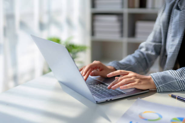 istock Close up of hand woman while working with laptop computer in office. 1803502884