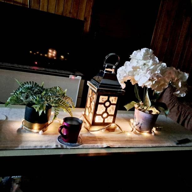 istock three lamps on a kitchen counter with potted plants, candles and a mug 1803516226