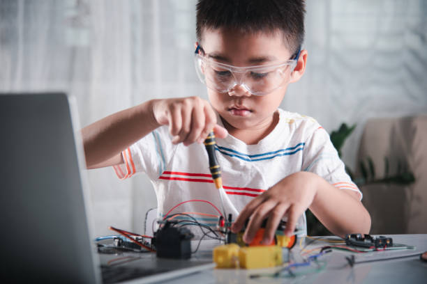 istock Asian kid boy assembling the robot car homework project at home 1803524339