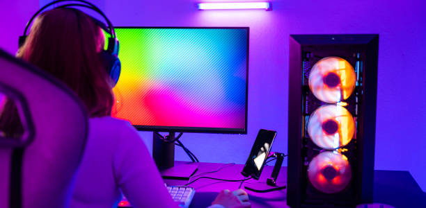istock Asian professional gamer playing online video game on desktop computer PC have colorful neon LED lights 1803524368