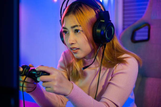 istock Gamer using joystick controller plays online video game with computer neon lights she winning 1803524897