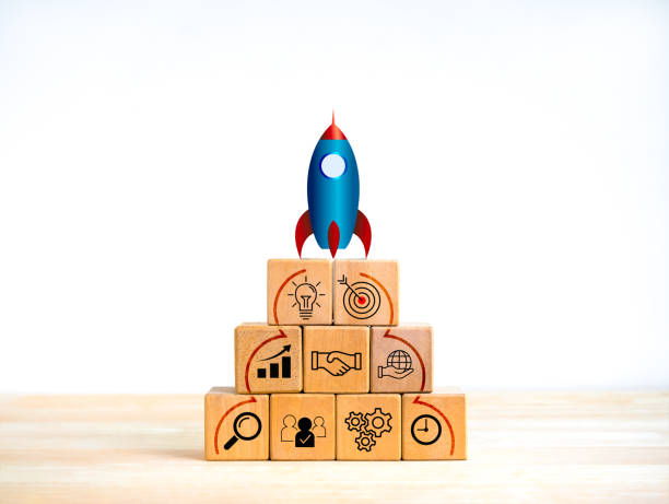 istock Business startup with growth success process for leadership concept. Space rocket launching on top of wooden cube blocks pyramid shape with strategy marketing action plan icons on white background. 1803574082
