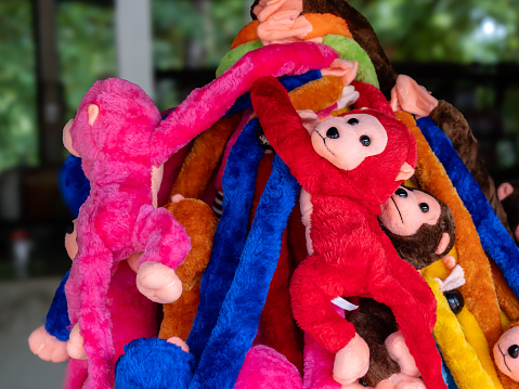 Multi-color cute little monkey dolls group in the souvenir shop at the local zoo.