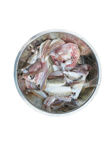 Many fish were butchered and decapitated, washed thoroughly, and placed in bowls.