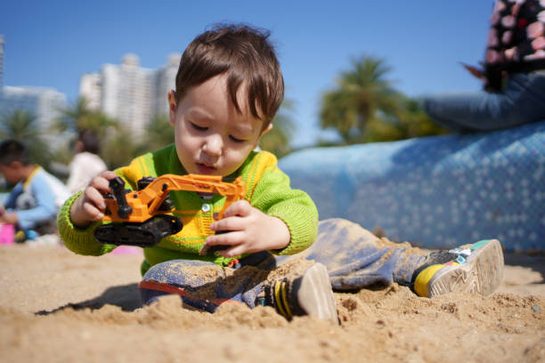 Mixed race children playing with sand