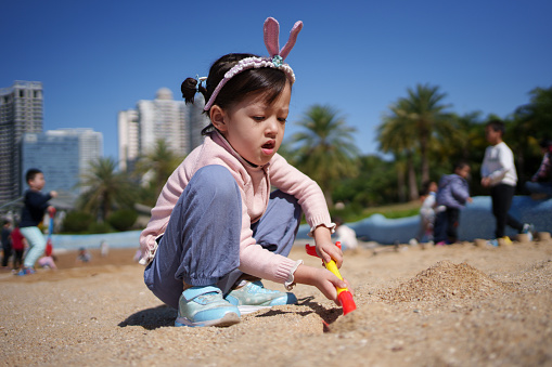 Mixed race children playing with sand