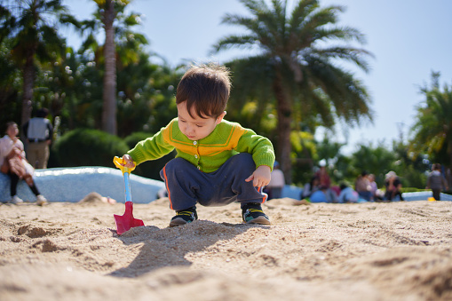 A little boy playing with sand