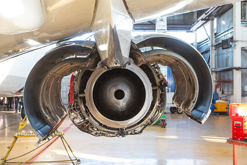 Rear view of an open jet engine of aircraft in aviation hangar