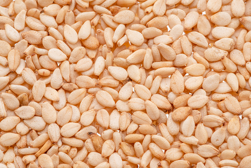 White sesame seeds closeup. Food background.