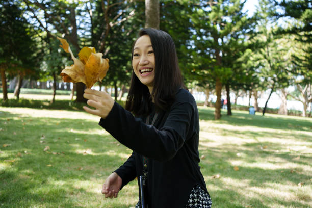 A woman holding fallen leaves