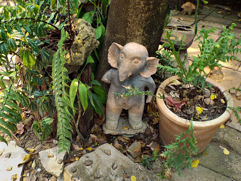 A figurine of an elephant standing near a tree in Thailand