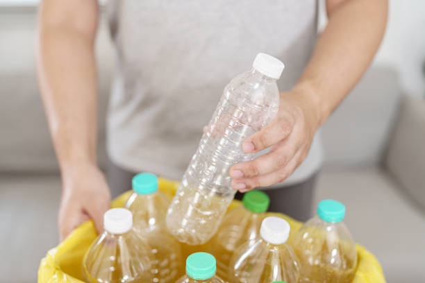 istock Home recycle eco green zero concept Man throwing empty plastic bottle in recycling bin with yellow garbage bags at home 1803630415