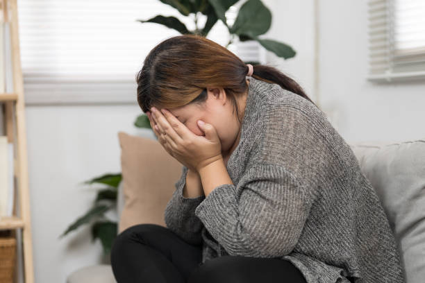 istock Sad Overweight plus size woman thinking about problems on sofa upset girl feeling lonely and sad from bad relationship or Depressed woman disorder mental health. 1803630424