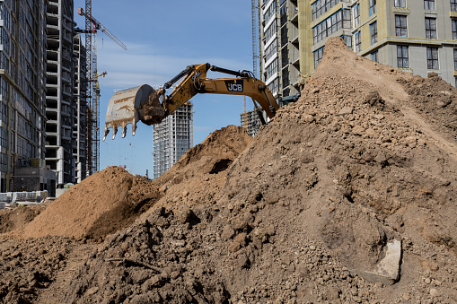 Minsk, Belarus, November 20, 2023 - Modern JCB excavator on the highway pipeline performs excavation work