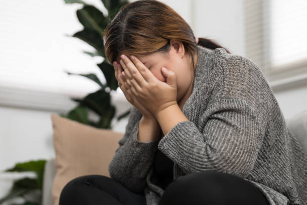 istock Sad Overweight plus size woman thinking about problems on sofa upset girl feeling lonely and sad from bad relationship or Depressed woman disorder mental health. 1803636159