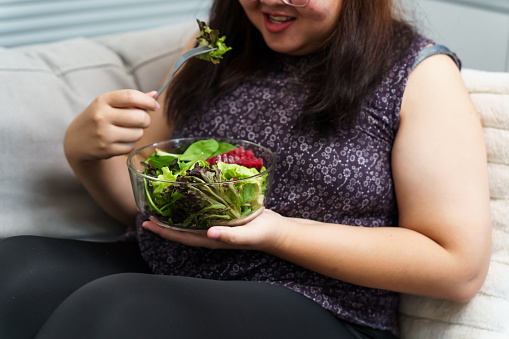 Asian Overweight woman dieting Weight loss eating fresh fresh homemade salad healthy eating concept Obese Woman with weight diet lifestyle