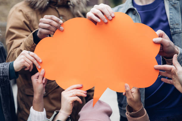 Hands holding a orange speech bubble.