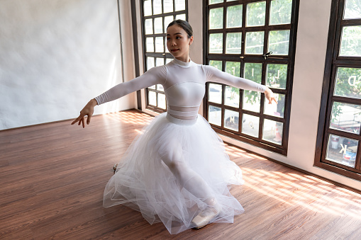 Modern Asian contemporary dancer poses in front of the studio background, full length isolated white.