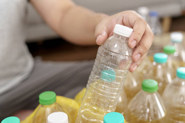 istock Home recycle eco green zero concept Man throwing empty plastic bottle in recycling bin with yellow garbage bags at home 1803642648