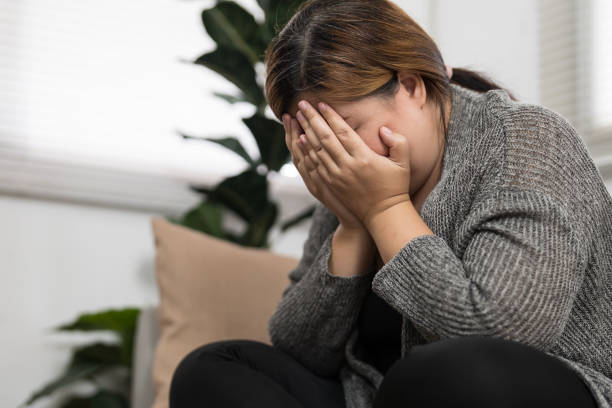 istock Sad Overweight plus size woman thinking about problems on sofa upset girl feeling lonely and sad from bad relationship or Depressed woman disorder mental health. 1803642967
