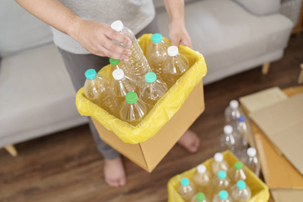 istock Home recycle eco green zero concept Man throwing empty plastic bottle in recycling bin with yellow garbage bags at home 1803642994