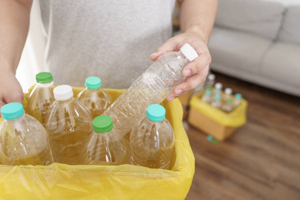 istock Home recycle eco green zero concept Man throwing empty plastic bottle in recycling bin with yellow garbage bags at home 1803644422