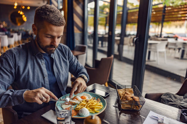 istock A starving man is having eggs for breakfast in a restaurant. 1803660240