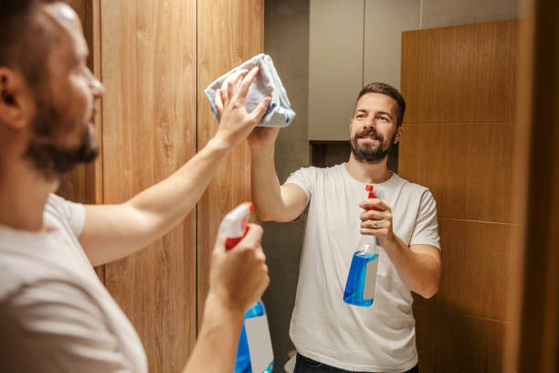 istock A tidy man is cleaning mirror in a bathroom with detergent and cloth. 1803664182