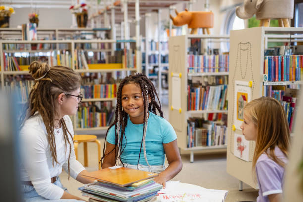 istock Young kids talking with the librarian 1803666847