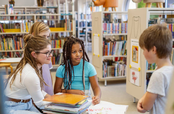istock Young kids talking with the librarian 1803666852