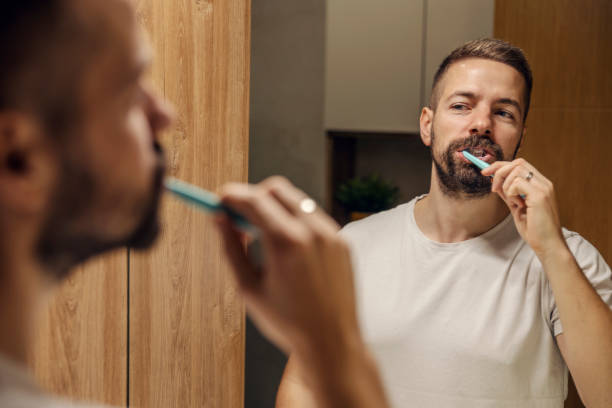 istock Reflection of a man brushing his teeth in a bathroom. 1803667943