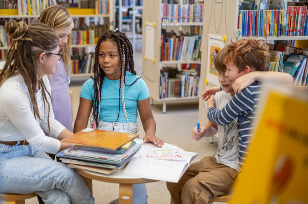 istock Young kids talking with the librarian 1803667950