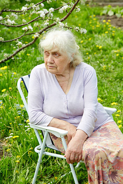 istock The grandmother in  garden under a blossoming apple-tree 180367936