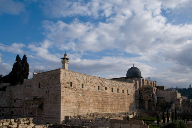 View of the southern wall and Al Aqsa mosque in Jerusalem's Old City The western and southern walls of the Temple Mount in Jerusalem with a view of the black-domed Al Aqsa mosque and minaret. al aksa stock pictures, royalty-free photos & images