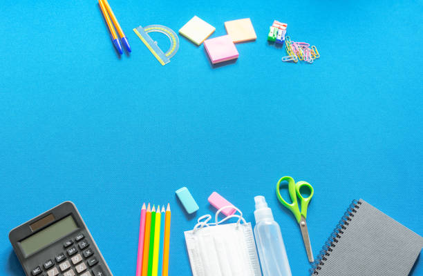 istock School supplies coronavirus prevention items. Bottom border on a blue tissue background. pandemic concept. 1803703823
