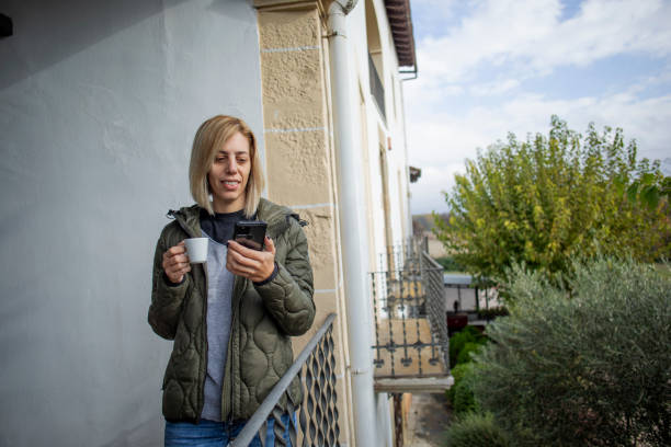 istock Woman using cell phone on a terrace 1803707041